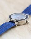 Low-angle profile showing the layered stainless steel case, raised crystal and numbered bezel plaque.