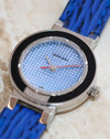 Macro photograph of the light blue geometric dial, silver hands and contrasting red seconds hand.