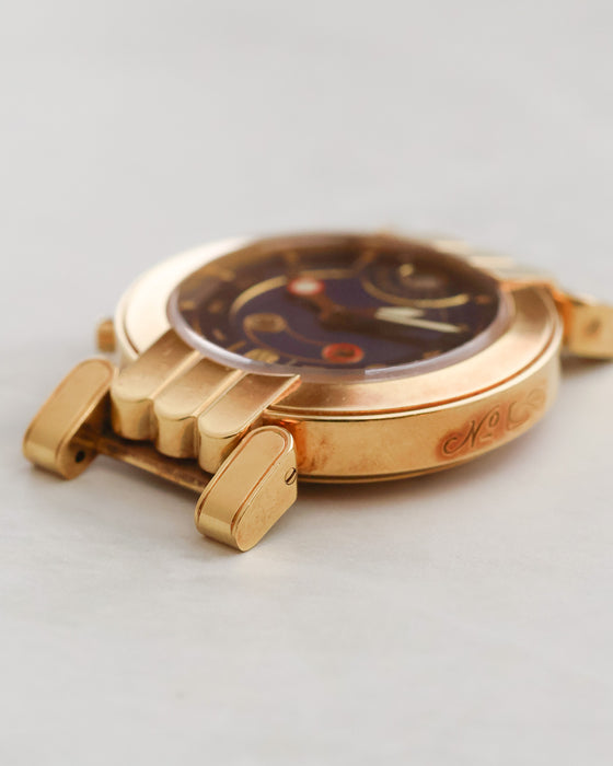 Opposite side profile of Harry Winston Greenwich showing the engraved case flank and distinctive gold lugs.