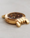 Low-angle photograph of Harry Winston Greenwich highlighting the depth of its blue dial and sculpted gold case.