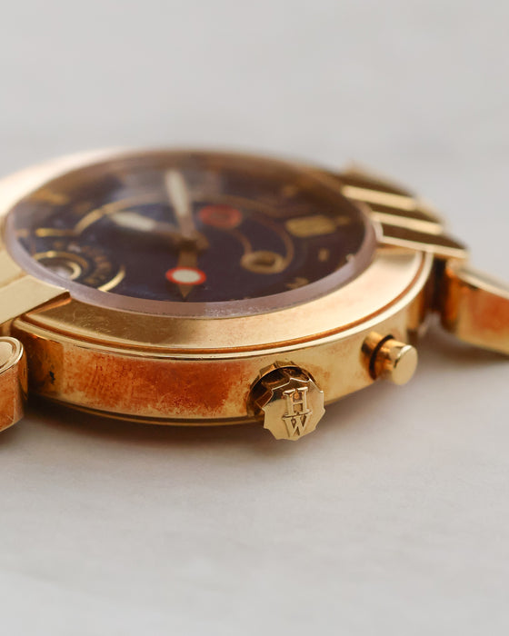 Close-up of Harry Winston Greenwich showing the signed crown, case-side pusher and surface patination.