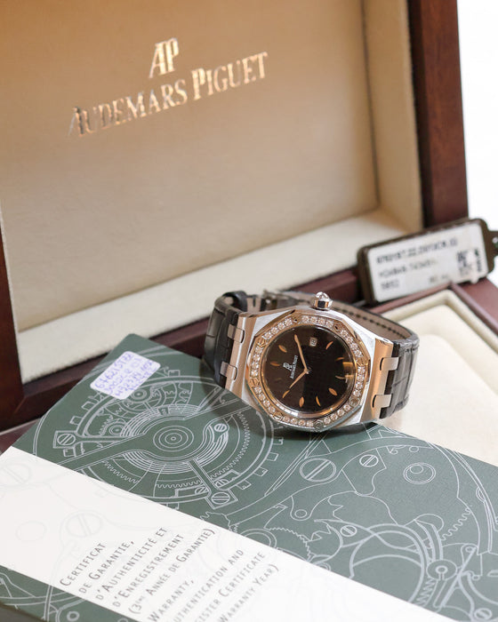 Audemars Piguet Royal Oak Lady 67601ST with black dial and diamond bezel displayed alongside its original box and warranty documentation.