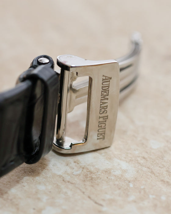 Close-up of the Audemars Piguet signed stainless steel deployant clasp attached to a black leather strap.