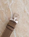 Close-up of the matching Vacheron Constantin 18K white gold deployant buckle attached to a textured taupe leather strap.