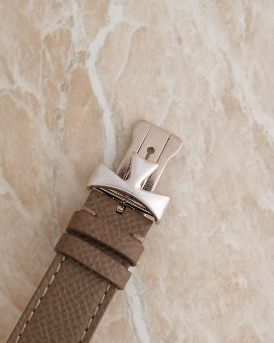 Close-up of the matching Vacheron Constantin 18K white gold deployant buckle attached to a textured taupe leather strap.