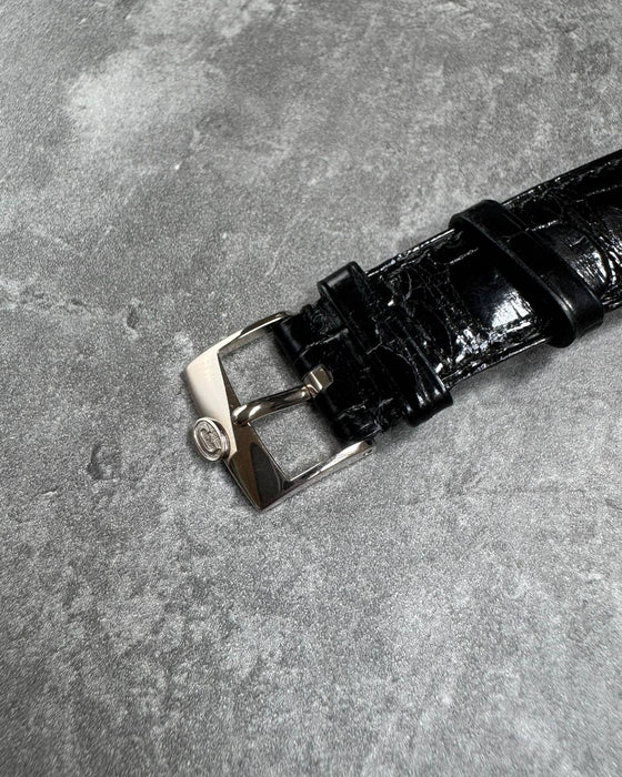 Close-up of original Concord 18K white gold buckle paired with factory alligator strap