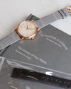 A. Lange & Söhne Saxonia 219.043 in rose gold with a grey alligator strap, photographed on its original presentation booklet.