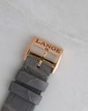 Close-up of the signed Lange rose gold pin buckle and grey alligator leather strap.