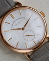 Macro photograph of the white mother-of-pearl dial with applied rose gold hour markers and subsidiary seconds.