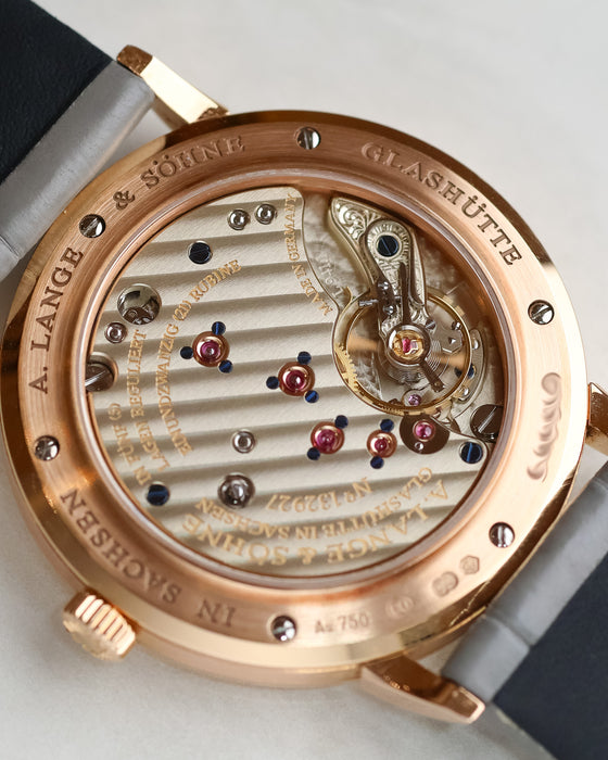 Detailed view through the sapphire caseback showing the Glashütte three-quarter plate, gold chatons and hand-engraved balance cock.