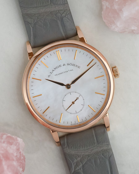 Angled photograph of the rose gold Saxonia with grey leather strap and natural mother-of-pearl dial.