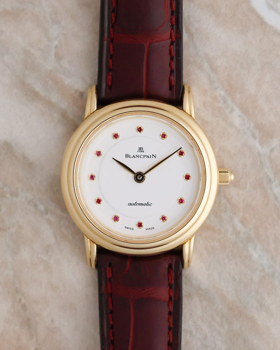 Front view of the Blancpain Lady Villeret Ref. 0096 featuring a white dial with twelve pink gemstone hour markers and an 18K yellow gold case.