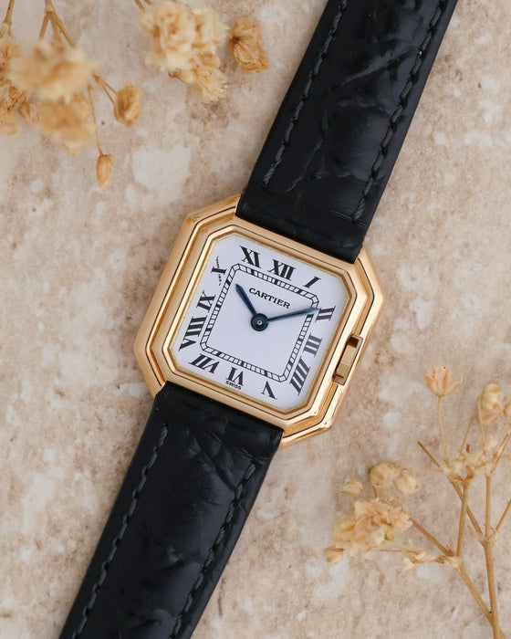 Angled overhead photograph of the Cartier Ceinture 6602 showcasing its stepped gold case and blued steel hands.