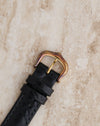 Close-up of the matching gold-tone pin buckle showing visible oxidation and patina on the metal.