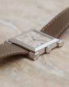 Side profile of the white gold Carrée Historique showing the polished case flank, stepped bezel and sculptural lugs.