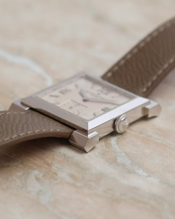 Side profile of the white gold Carrée Historique showing the polished case flank, stepped bezel and sculptural lugs.