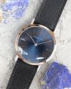 Angled overhead view of an Audemars Piguet blue dial watch photographed alongside blue mineral stones.
