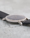Side view of the Audemars Piguet highlighting its straight lugs, slim case and black textured leather strap.