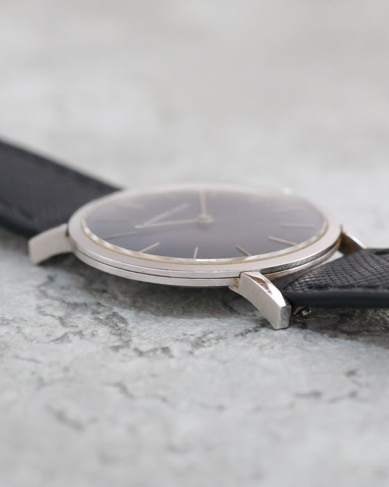 Side view of the Audemars Piguet highlighting its straight lugs, slim case and black textured leather strap.