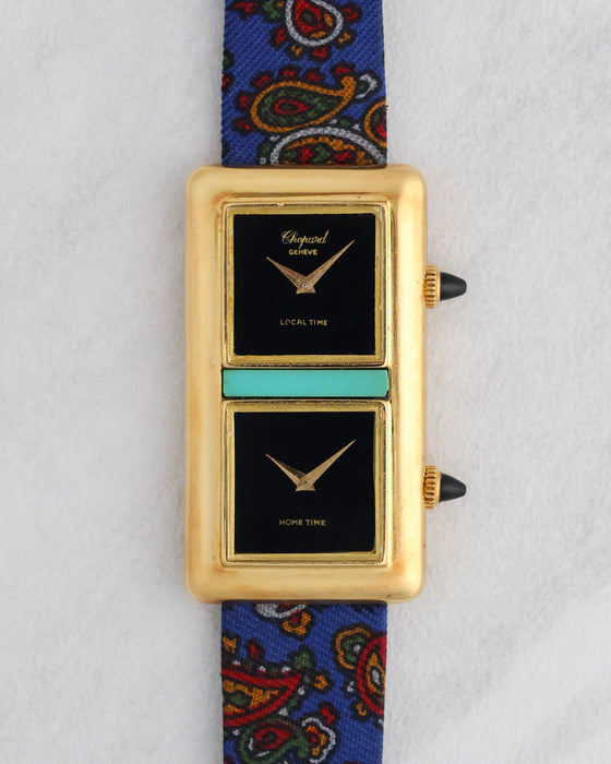 Front view of the Chopard Kutchinsky Dual Time with twin black onyx dials, turquoise centrepiece and blue paisley strap.