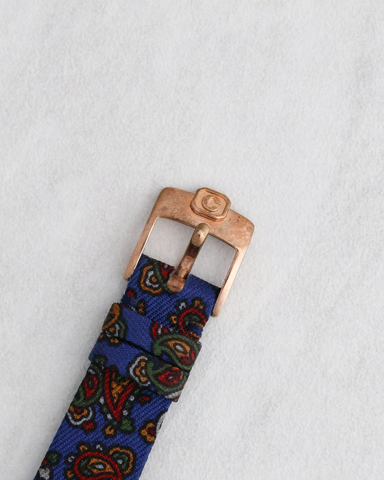 Front view of the original Chopard gold-plated pin buckle attached to the blue paisley strap.