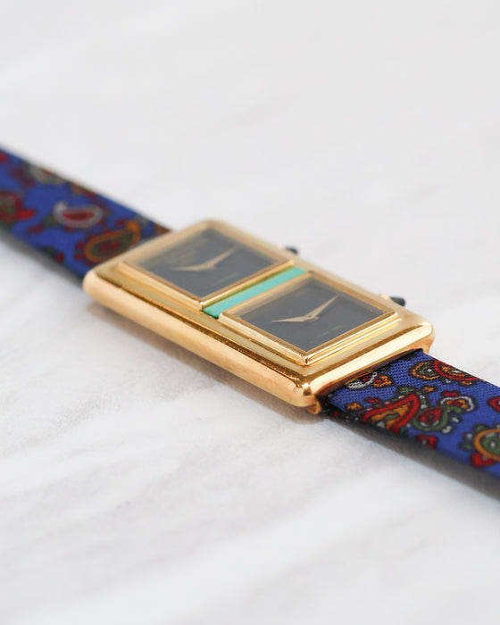 Low-angle side view of the Chopard Dual Time showing its raised rectangular dials and polished yellow gold case.
