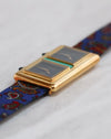 Low-angle view of the Chopard Kutchinsky Dual Time highlighting the rounded gold case and blue patterned strap.