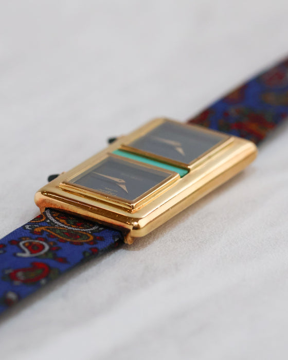 Low-angle view of the Chopard Kutchinsky Dual Time highlighting the rounded gold case and blue patterned strap.