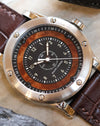 Detailed view of the black dial, natural elm burl wood surround, Arabic numerals and central seconds hand.