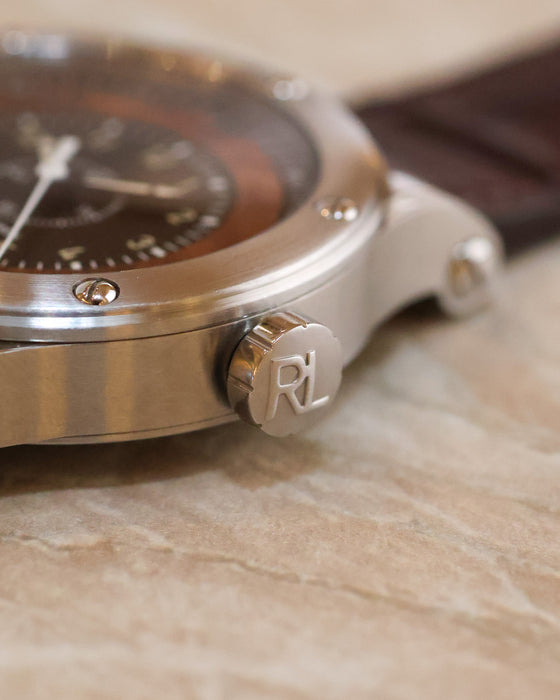 Macro photograph of the stainless steel crown engraved with the Ralph Lauren RL monogram.