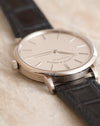 Angled side view showing the slender lugs and polished white gold case.