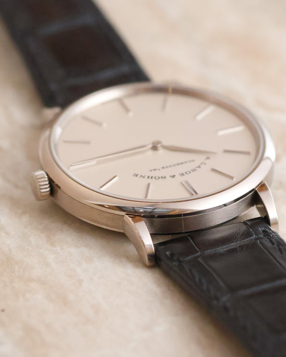 Angled side view showing the slender lugs and polished white gold case.