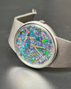 Close-up of Girard-Perregaux opal dial displaying iridescent hues of blue, green, and red under acrylic crystal