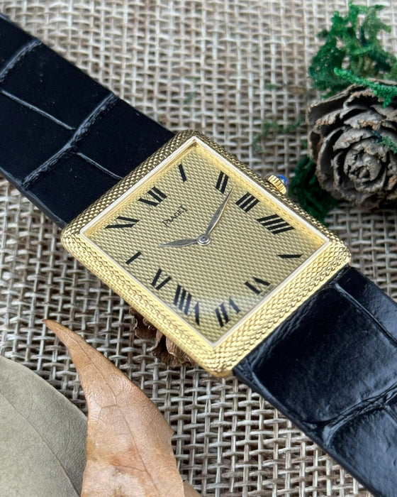 Elegant Piaget 9152 rectangular gold watch with matching guilloché case and dial, featuring slim gold hands