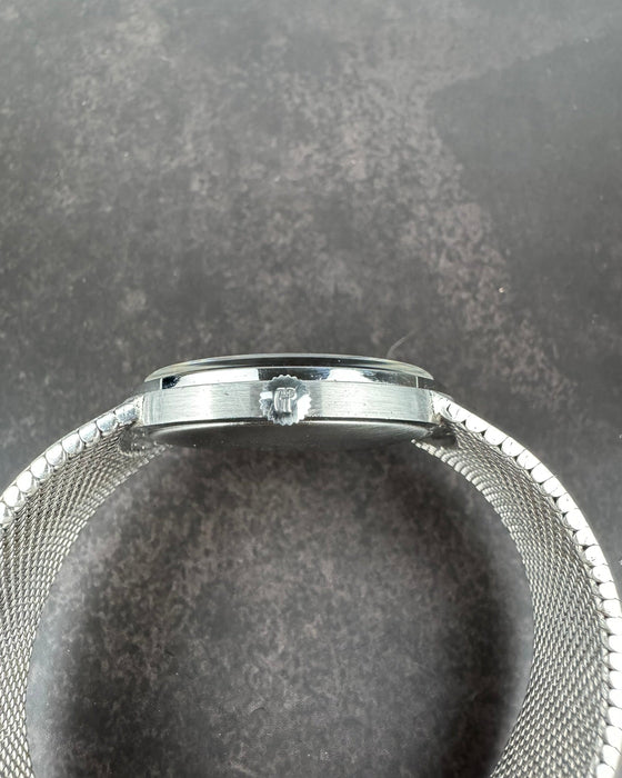 Side view of Girard-Perregaux opal dial watch showing steel crown and curved case profile